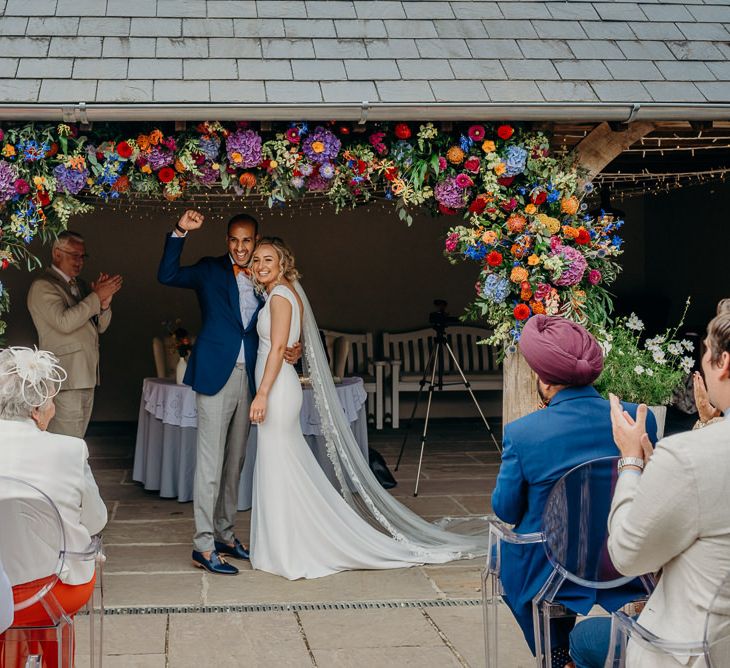 Outdoor ceremony with bright wedding decorations and stunning colourful flowers