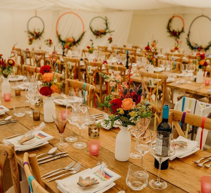 Bright wedding decorations and wooden banquet tables in marquee wedding