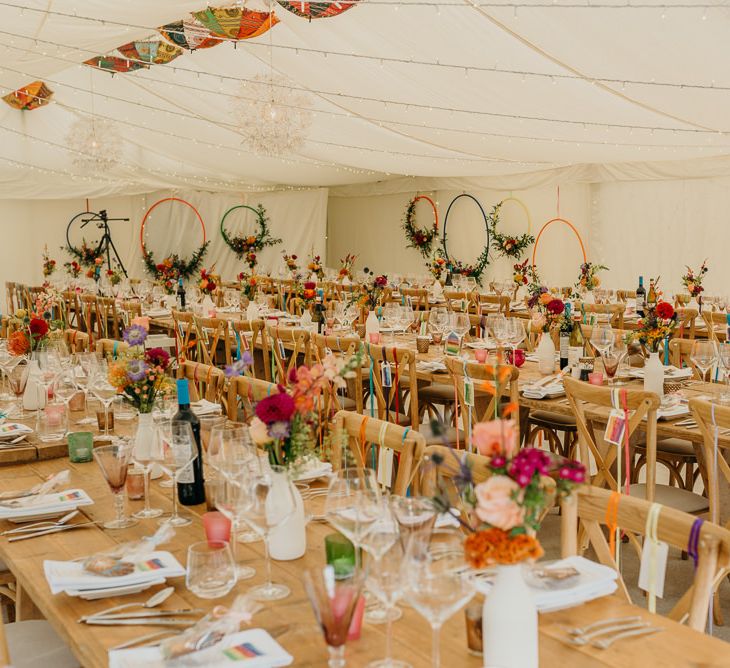 Bright wedding decorations and wooden banquet tables in marquee wedding