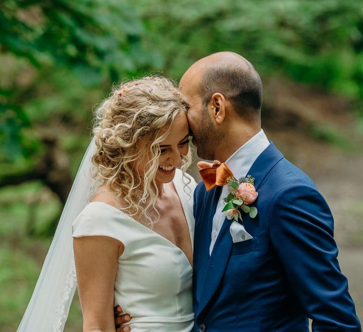 Curly haired bridal updo with simple wedding dress