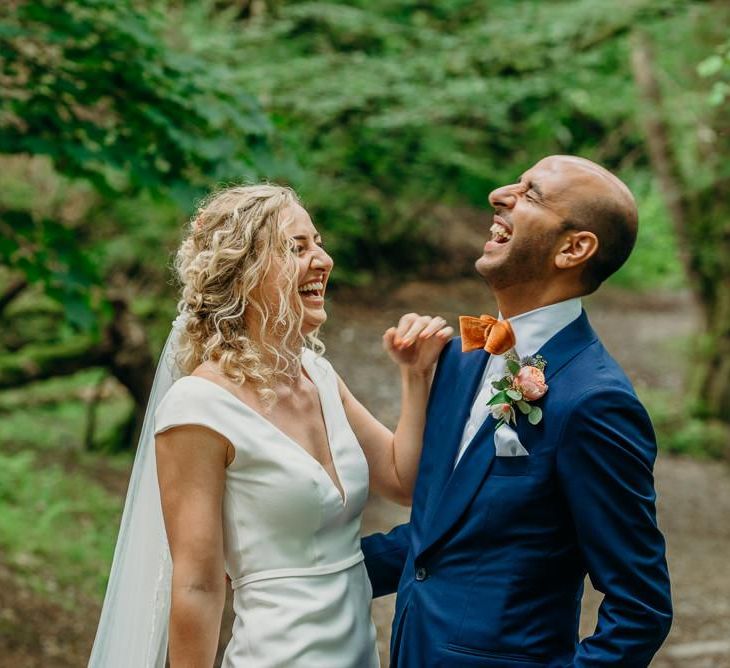 Groom wears blue wedding suit with bright bowtie