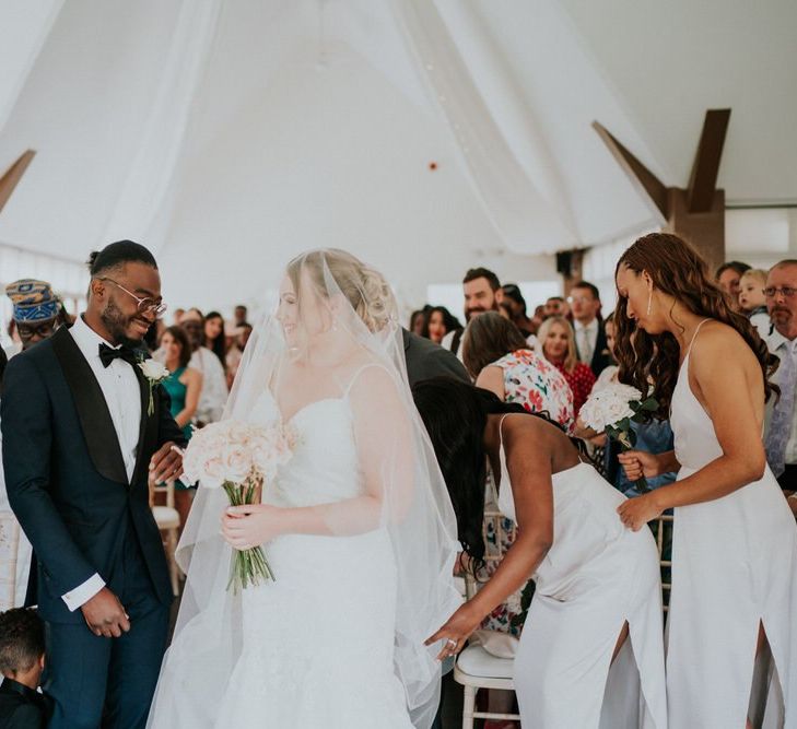 Bride and groom meet at the altar with bride in lace Morilee wedding dress