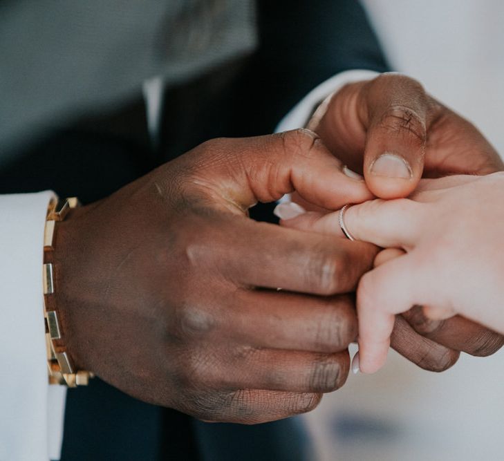 Groom putting on his brides wedding band