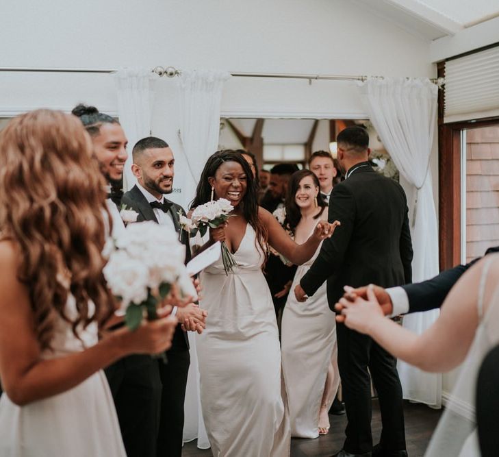 Bridesmaid in beige dresses congratulating the bride and groom