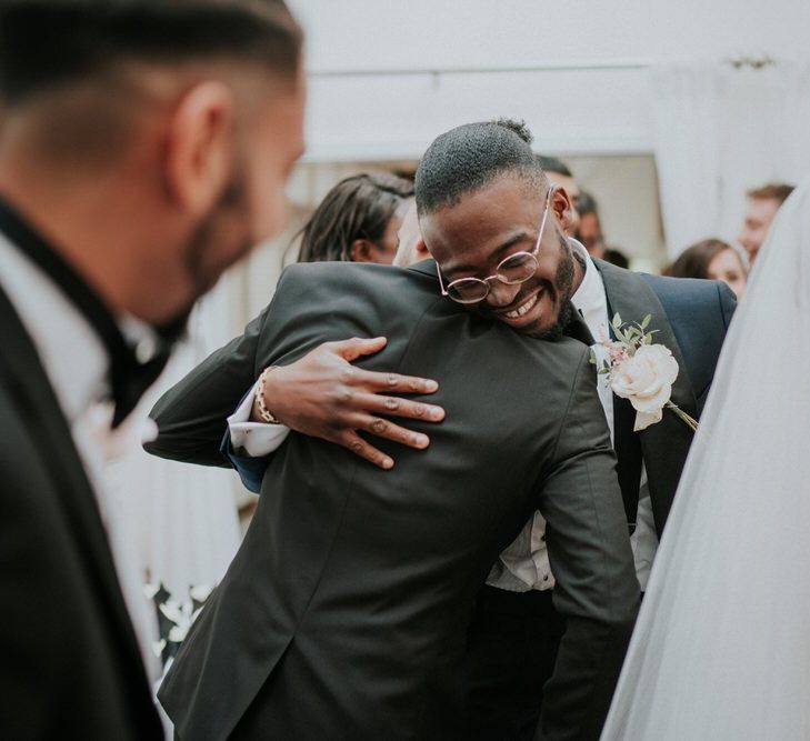 Groomsman hugging the groom