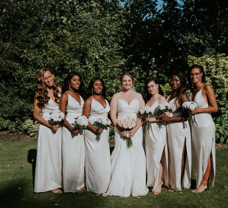 Bridal party portrait with bridesmaids in off white dresses and bride in Morilee wedding dress