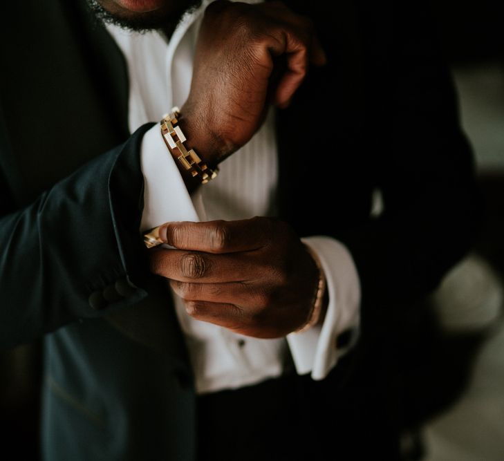 Groom putting on cufflinks