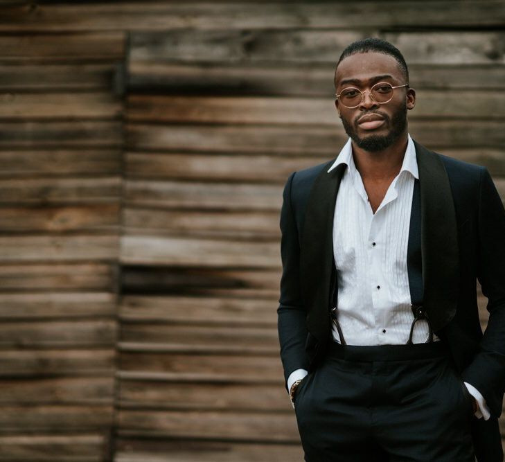 Stylish groom in black tie suit