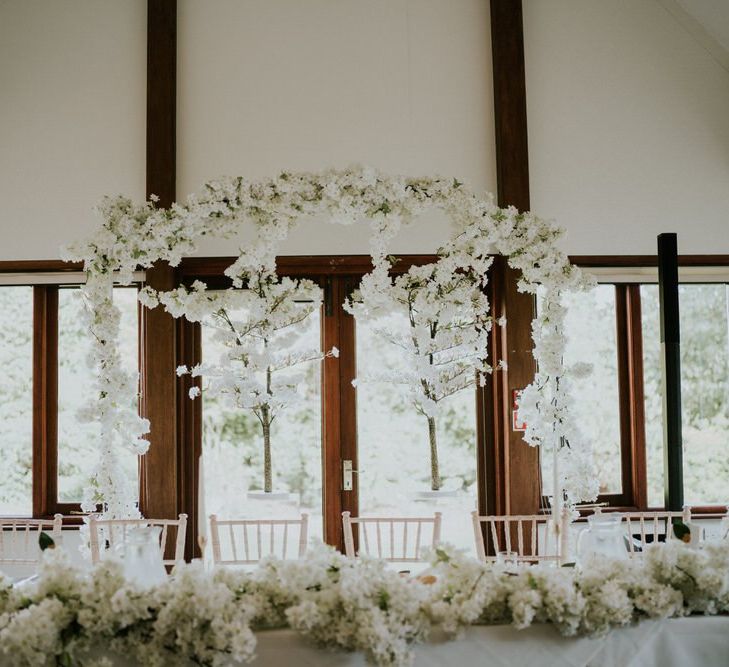 White blossom top table flowers and backdrop