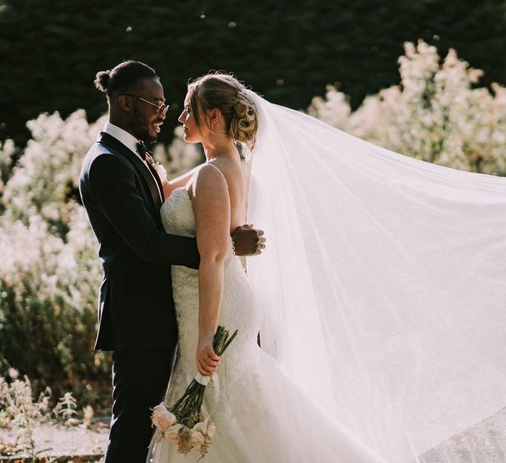 Bride and groom portrait with bride in Morilee wedding dress and floating veil