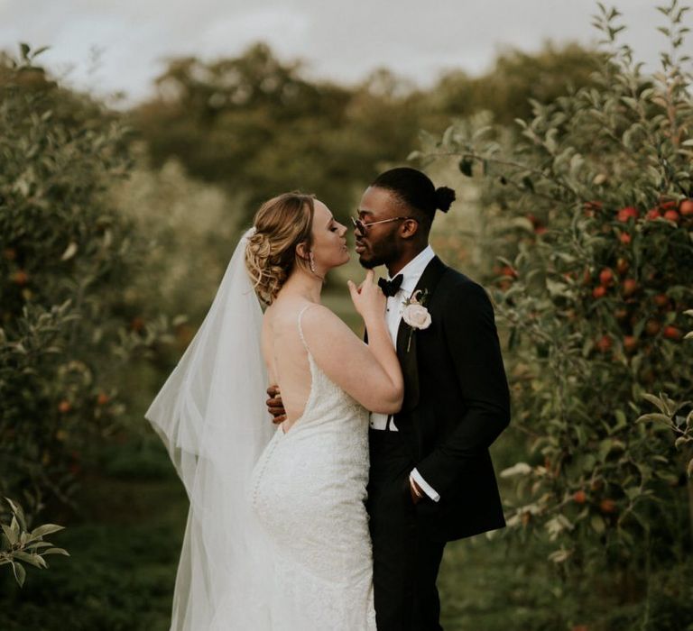 Bride in fishtail Morilee wedding dress and groom in tuxedo