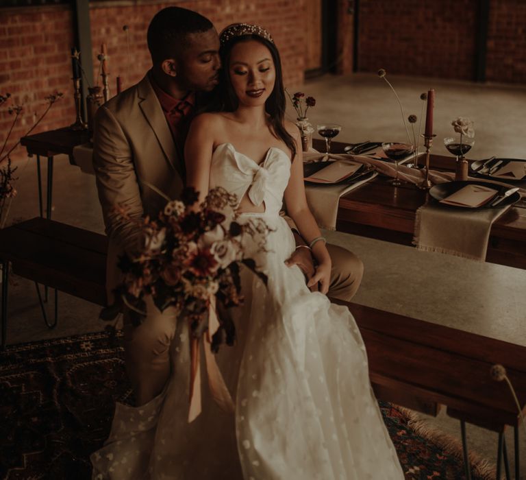 Groom embracing his bride in a E&amp;W Couture wedding dress