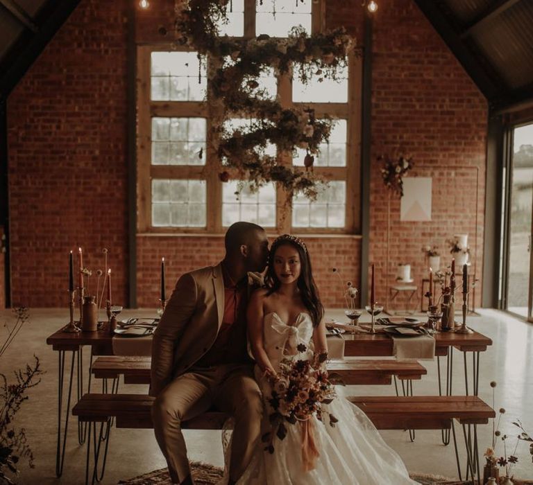 Bride and groom sitting at intimate wedding reception table at the Giraffe Shed