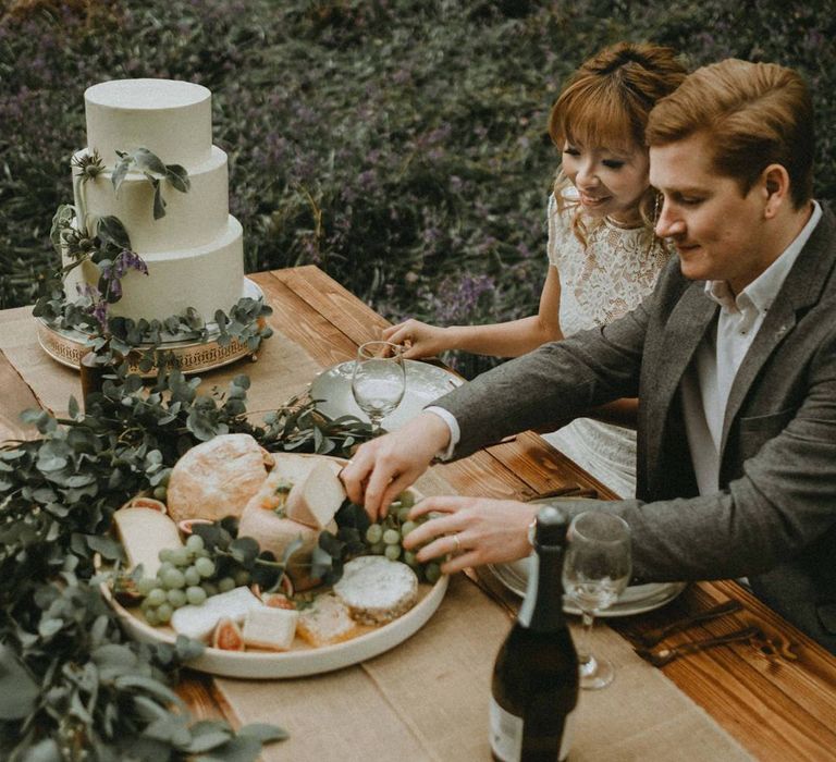 Bride and Groom Enjoying Cheese and Bread Grazing Table