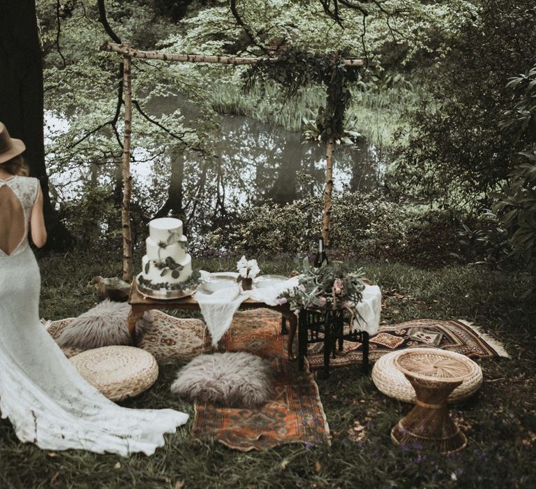 Boho Grazing Table in the Woods with Rugs, Poufs and Wicker Stools