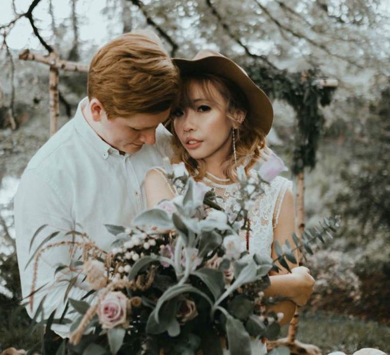 Groom Embracing His Boho Bride in Felt Hat