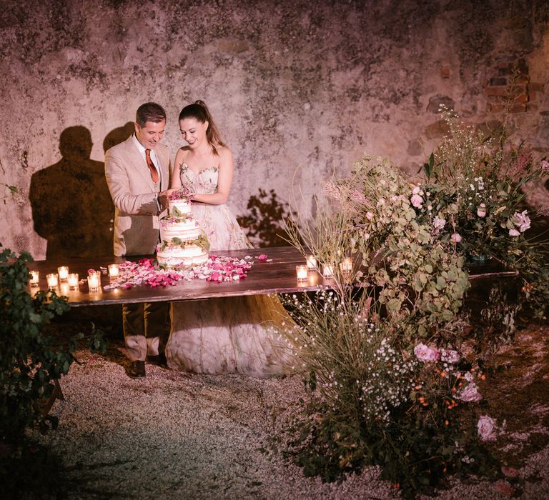 Cake Cutting | Naked Wedding Cake | Pink Petals | Tea Lights | Fairytale Tuscan Wedding with Bride in Embroidered Dress | Andrea &amp; Federica Photography