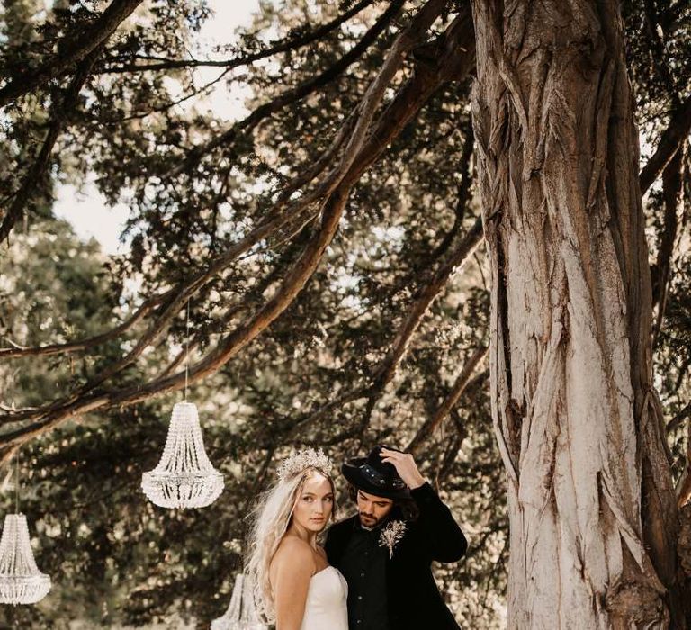 Bride and groom standing under chandeliers