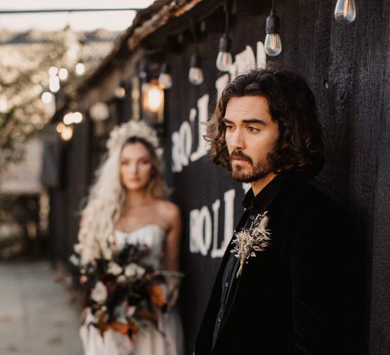 Groom in black shirt and velvet jacket for Halloween wedding