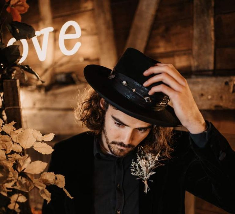 Groom in black shirt, hat and blazer at Halloween wedding