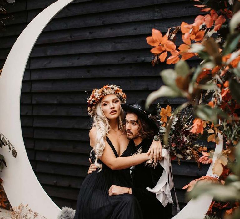 Bride sitting on her grooms lap at Halloween wedding