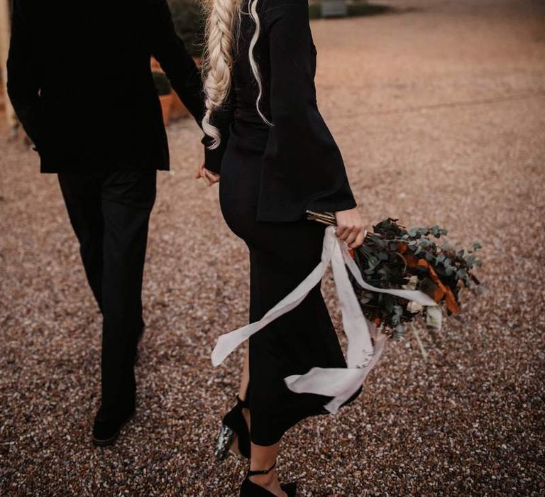 Stylish bride in black wedding dress and orange flower crown