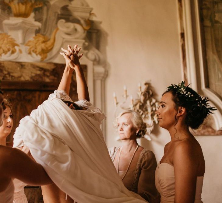 Wedding Morning Bridal Preparations with Bridesmaids Helping Bride into Her Wedding Dress