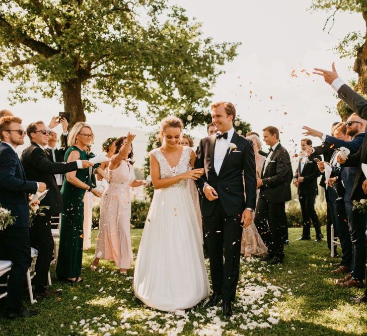 Confetti Moment with Bride in Bespoke Wedding Dress and Groom in Black Tie Suit Walking Up The Aisle