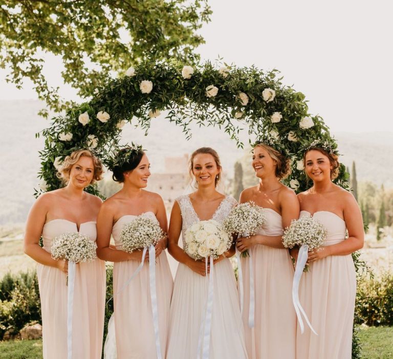 Bridal Party Portrait in Front of a White and Green Floral Arch