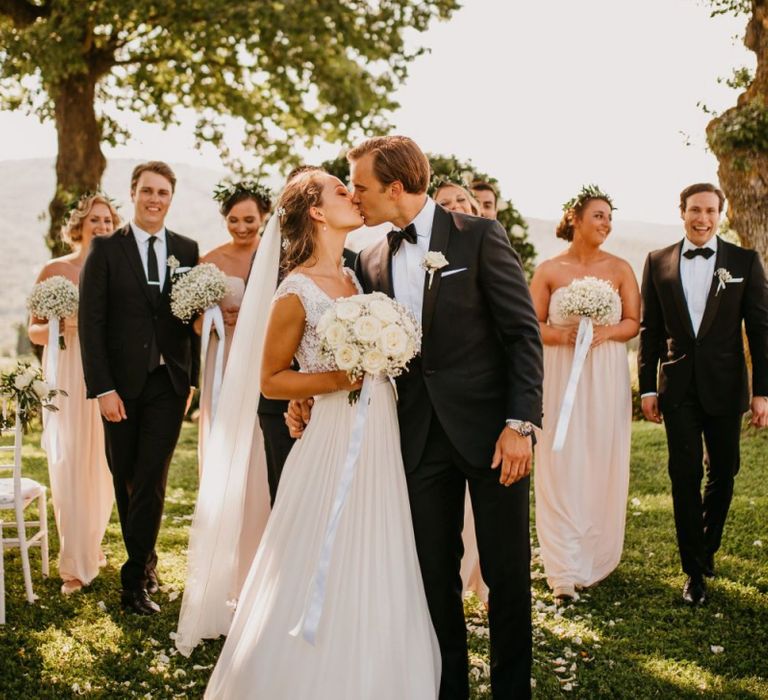 Bride and Groom Kissing in Front of of their Wedding Party