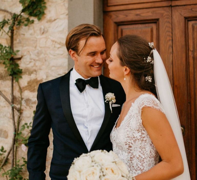 Bride in Bespoke Wedding Dress  and Groom in Black Tie Suit Laughing Together