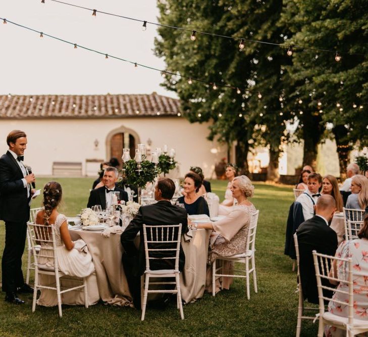 Groom in Tuxedo and Bow Tie Giving His Wedding Speech at The Outdoor Wedding Reception