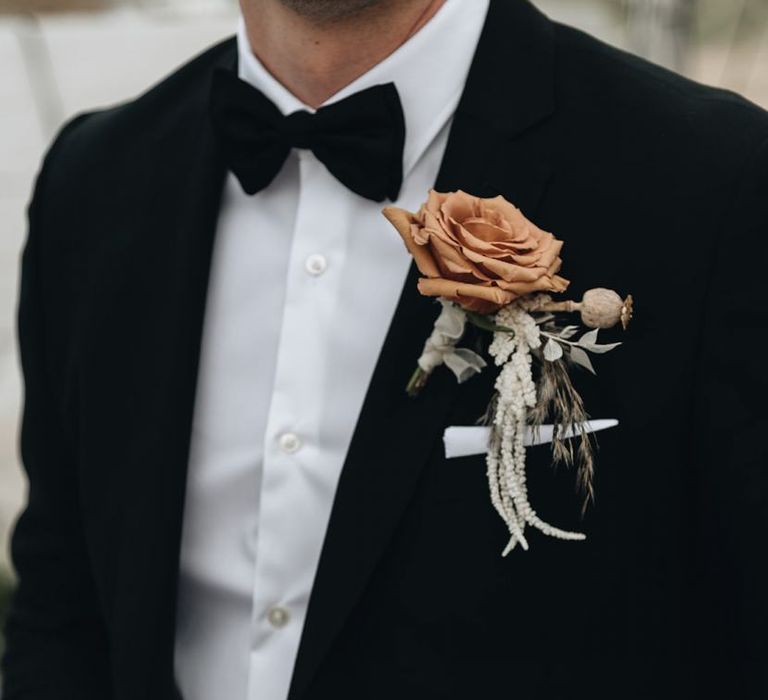 Groom in Tuxedo with Muted Orange Buttonhole