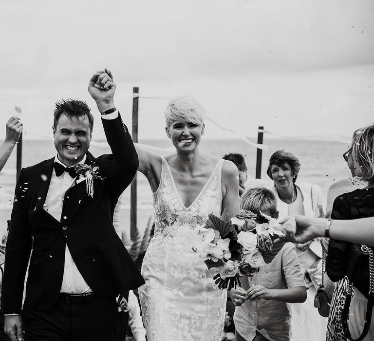 Bride with Short hair in Made With Love Wedding Dress and Groom in Tuxedo Walking Up the Aisle asHusband and Wife