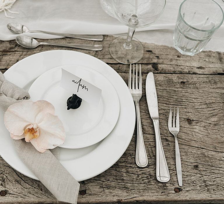 Place Setting with White Place, Linen Napkin and Orchid