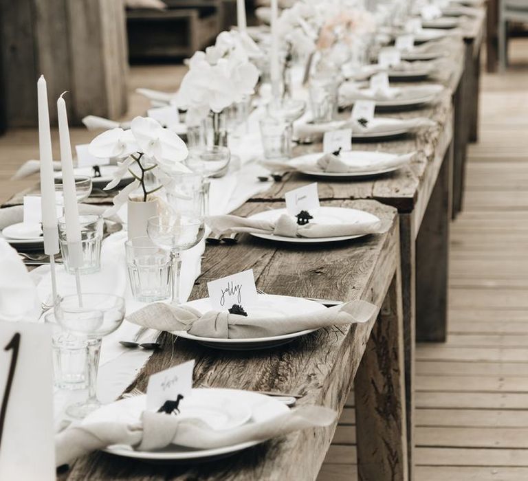 Wooden Table Scape with White Orchid Flowers, Candles and Natural Linens