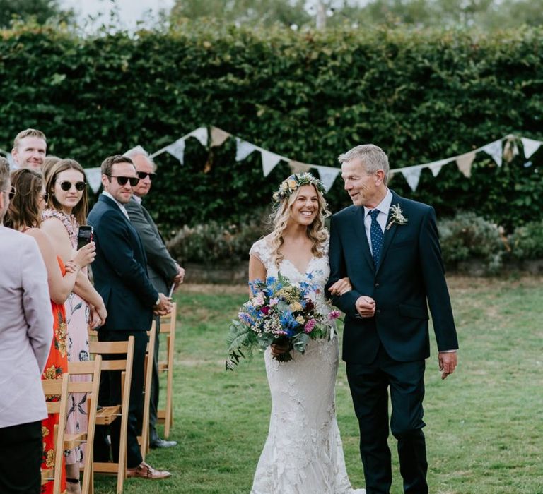 Outdoor Wedding Ceremony Bridal Entrance in Lace Watters Wedding Dress and Colourful Flower Crown and Wedding Bouquet