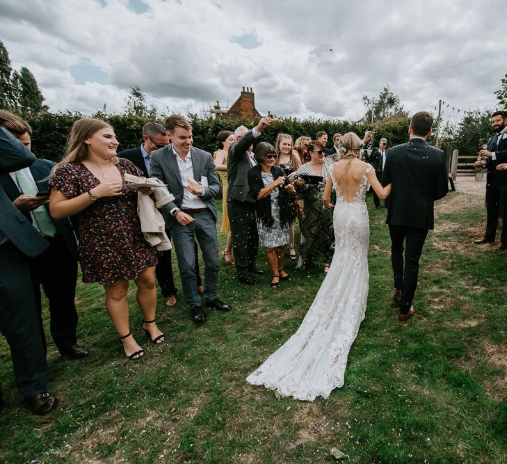 Confetti Moment with Bride in Lace Watters Wedding Dress and Groom in Navy Hugo Boss Suit