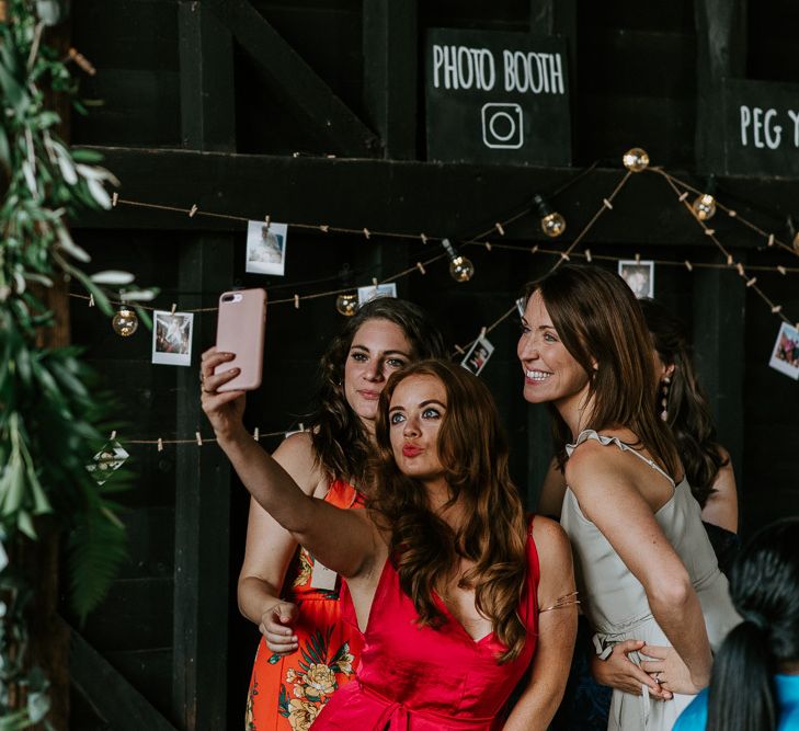 Wedding Guests Selfie in Front of Photo Booth Corner