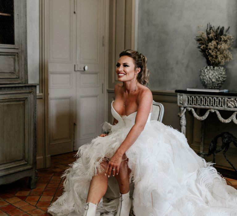 Bride in Stephanie Allin Ostrich Feather Wedding Dress Putting On Her Wedding Boots