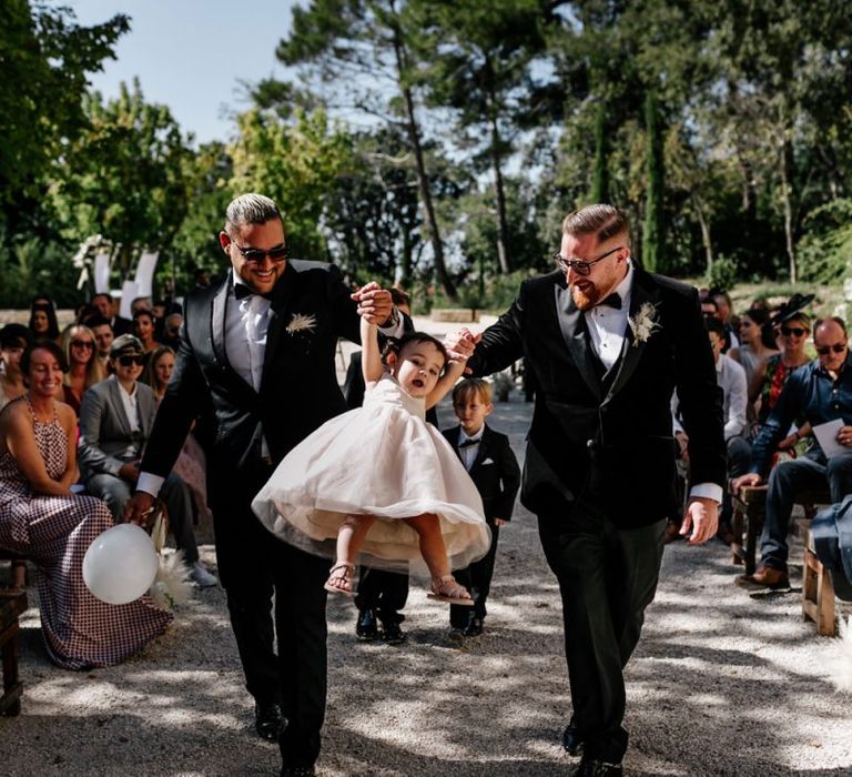 Groom and Best Man Walking Down the Aisle with the Flower Girl