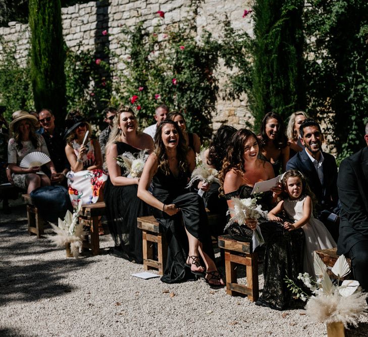 Guests Sitting on Benches at an Outdoor Wedding Ceremony