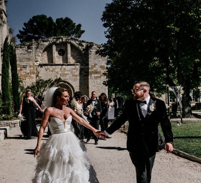 Bride in Stephanie Allin Wedding Dress and Groom in Tuxedo Holding Hands