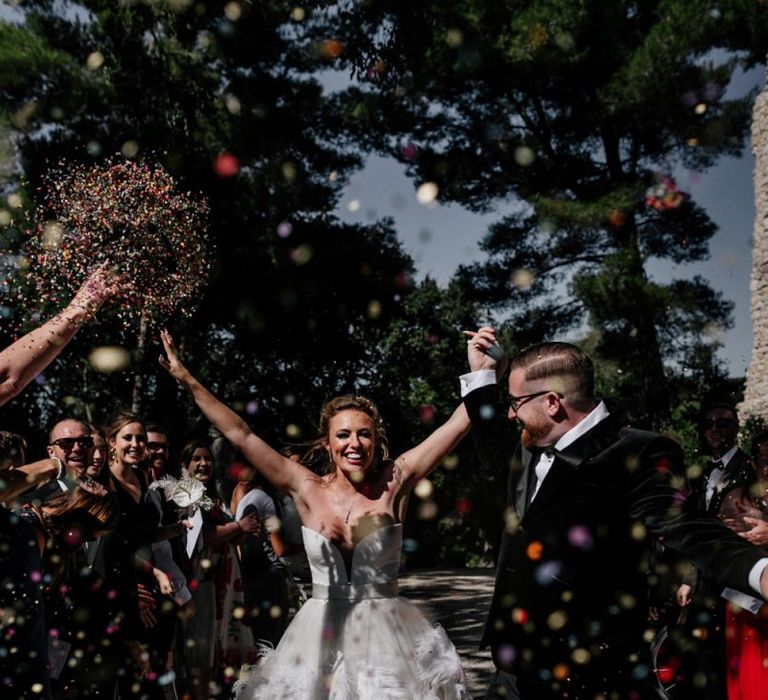 Confetti Moment with Bride in Off the Shoulder Wedding Dress and Groom in Moss Bros. Suit