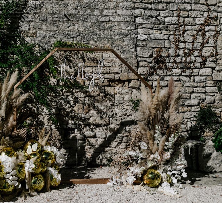 Gold Hexagon Backdrop with Neon Sign, Glitter Balls and Pampas Grass