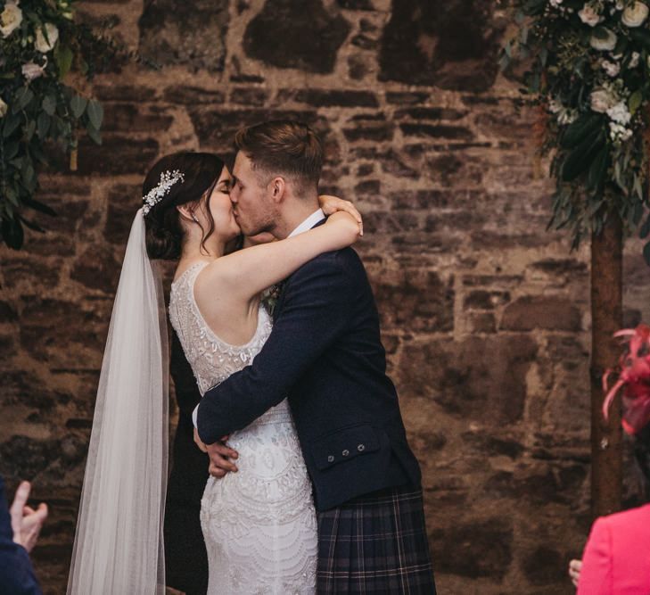 Bride and groom kiss at ceremony