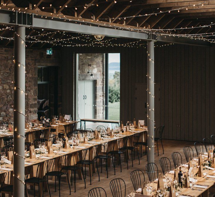 Rustic wedding breakfast at Guardswell Farm with fairy light canopy