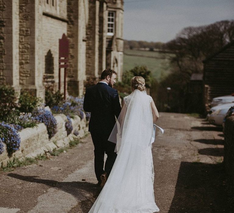 Bride and Groom Walking Through the Church Courtyard