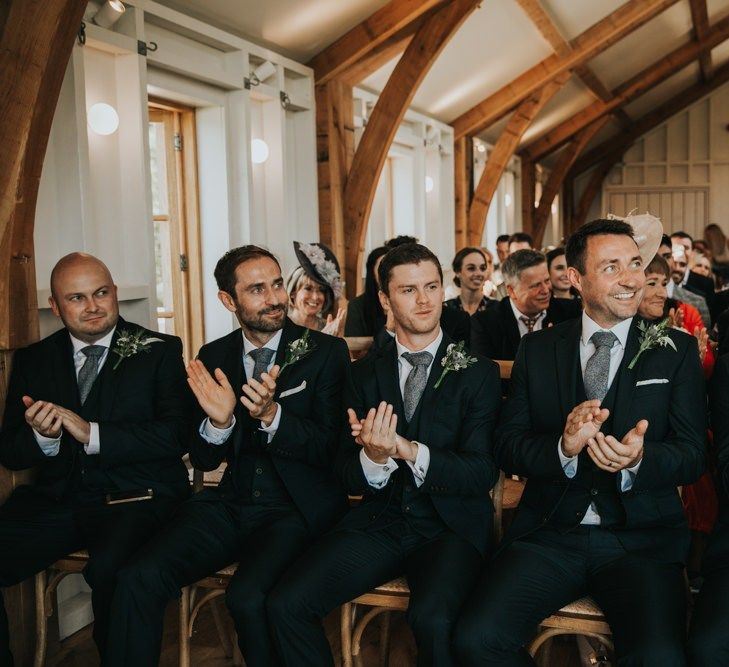 Groomsmen applaud the couple during ceremony