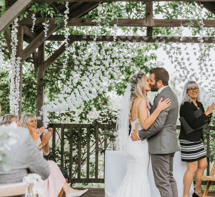 Bride in Lace Wedding Dress and Groom in Wool Suit Kissing During Wedding Ceremony